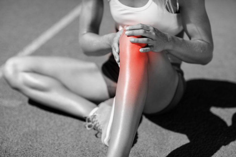 women holding her knee due to acute inflammation and knee pain